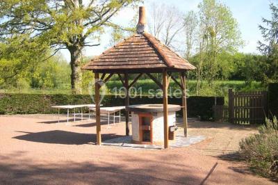 Salle décorée avec des tables hautes blanches, des nappes et des éléments suspendus dans un style épuré et chaleureux.