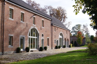 Miniature Location salle Hannut (Liège) - Château d'Avin #20 Manoir blanc entouré de pelouses et d'arbres, avec un étang au premier plan reflétant le bâtiment.