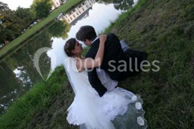 Miniature Location salle Hannut (Liège) - Château d'Avin #33 Manoir blanc entouré de pelouses et d'arbres, avec un étang au premier plan reflétant le bâtiment.