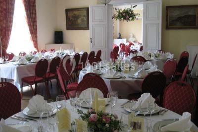 Salle de réunion avec une grande table en bois, chaises noires, bouteilles d'eau et vue sur l'extérieur par des baies…