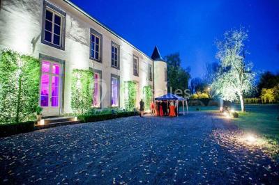 Salle de réunion avec une grande table en bois, chaises noires, bouteilles d'eau et vue sur l'extérieur par des baies…