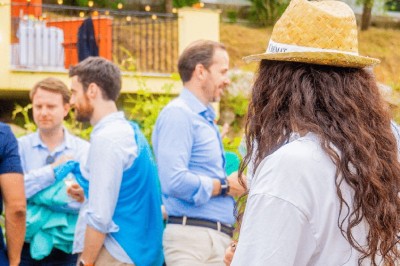 Un groupe de personnes discute au milieu d'un vignoble verdoyant par une journée ensoleillée.