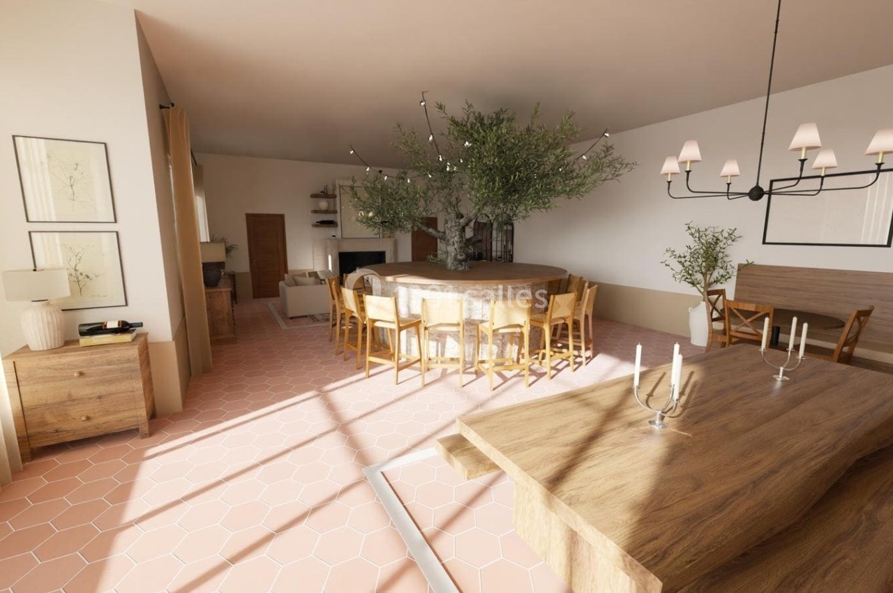 Salle à manger lumineuse avec grande table en bois, chaises assorties, lustre moderne et décoration végétale.