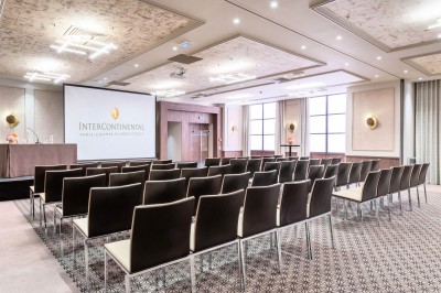 Sèche-cheveux noir dans un étui rigide ouvert de couleur marron, posé sur une surface claire.