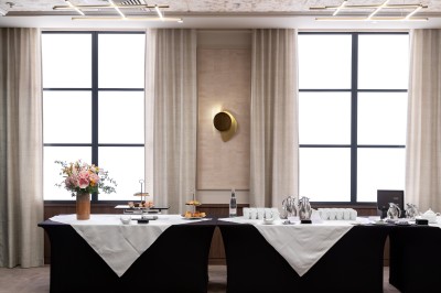 Sèche-cheveux noir dans un étui rigide ouvert de couleur marron, posé sur une surface claire.