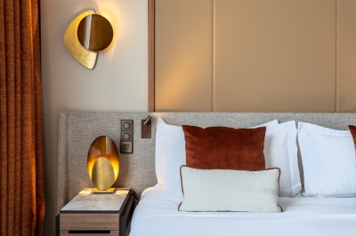 Sèche-cheveux noir dans un étui rigide ouvert de couleur marron, posé sur une surface claire.