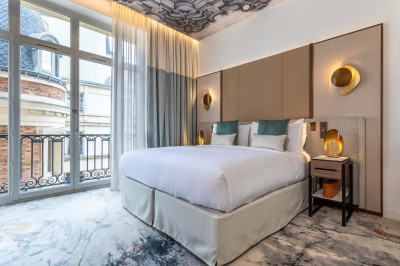 Sèche-cheveux noir dans un étui rigide ouvert de couleur marron, posé sur une surface claire.