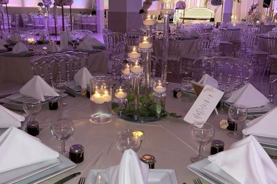 Décoration de salle avec fleurs roses, chandeliers dorés et rideaux scintillants dans un cadre élégant et lumineux.