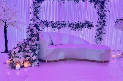 Décoration de salle avec fleurs roses, chandeliers dorés et rideaux scintillants dans un cadre élégant et lumineux.