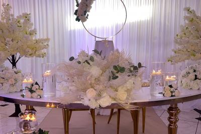 Décoration de salle avec fleurs roses, chandeliers dorés et rideaux scintillants dans un cadre élégant et lumineux.