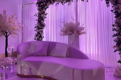 Décoration de salle avec fleurs roses, chandeliers dorés et rideaux scintillants dans un cadre élégant et lumineux.