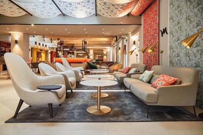 Façade d'un hôtel moderne à plusieurs étages avec balcons, entrée principale et enseigne ’Mercure Hotel’.