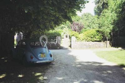 Miniature Location salle Audierne (Finistère) - Manoir de Menez Bras #18 Lit double avec couvre-lit rouge à motifs, encadré par deux tables de chevet, éclairé par des appliques murales.