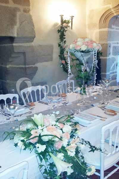 Location salle Audierne (Finistère) - Manoir de Menez Bras #9 Table élégamment décorée avec des fleurs blanches et roses, nappes blanches et vaisselle raffinée dans une salle en pierre.