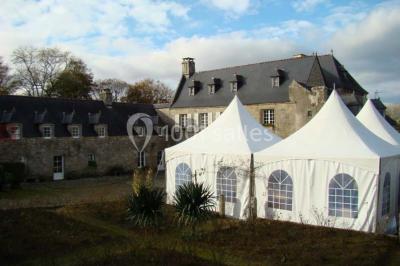 Miniature Location salle Audierne (Finistère) - Manoir de Menez Bras #3 Lit double avec couvre-lit rouge à motifs, encadré par deux tables de chevet, éclairé par des appliques murales.