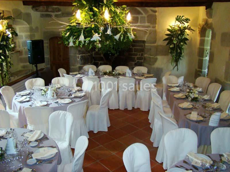 Location salle Audierne (Finistère) - Manoir de Menez Bras #10 Salle décorée pour un événement avec tables rondes dressées, nappes blanches et arrangements floraux suspendus.