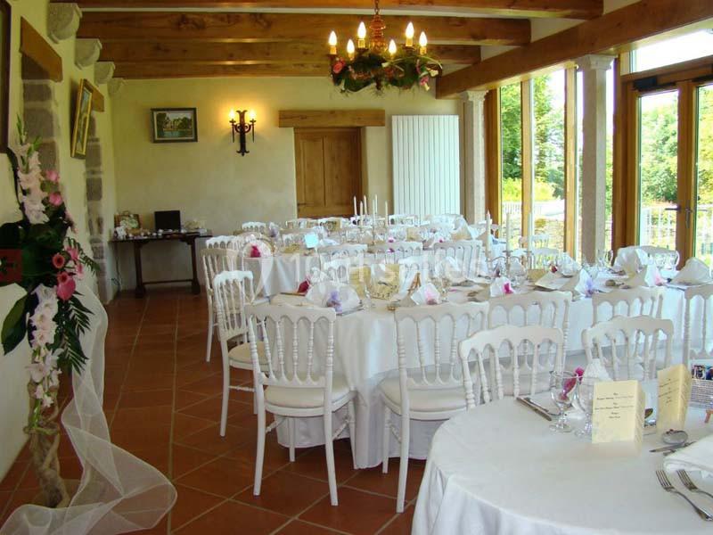 Location salle Audierne (Finistère) - Manoir de Menez Bras #15 Salle de réception lumineuse avec tables rondes dressées, chaises blanches et décoration florale.