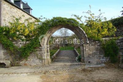 Miniature Location salle Audierne (Finistère) - Manoir de Menez Bras #17 Lit double avec couvre-lit rouge à motifs, encadré par deux tables de chevet, éclairé par des appliques murales.