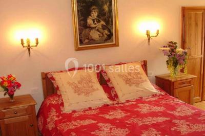 Miniature Location salle Audierne (Finistère) - Manoir de Menez Bras #22 Lit double avec couvre-lit rouge à motifs, encadré par deux tables de chevet, éclairé par des appliques murales.