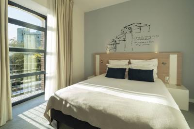 Mobilier de terrasse moderne avec vue sur un château médiéval sous un ciel bleu partiellement nuageux.