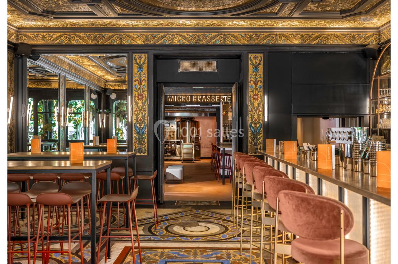 Intérieur d'une microbrasserie avec un bar élégant, des tabourets en velours et une décoration richement ornée.