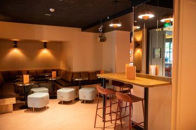 Groupe de personnes dans une salle ornée de miroirs et de lustres, avec un DJ jouant de la musique en arrière-plan.