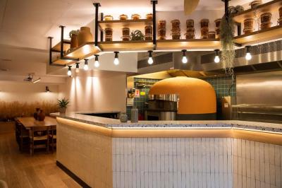 Groupe de personnes dans une salle ornée de miroirs et de lustres, avec un DJ jouant de la musique en arrière-plan.