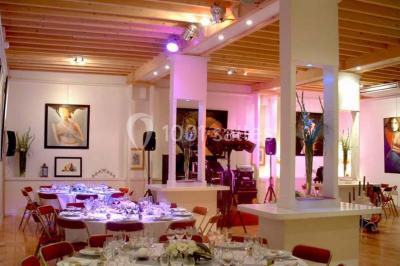 Terrasse en bois longeant un bâtiment en briques avec vue sur un jardin arboré sous un ciel bleu.