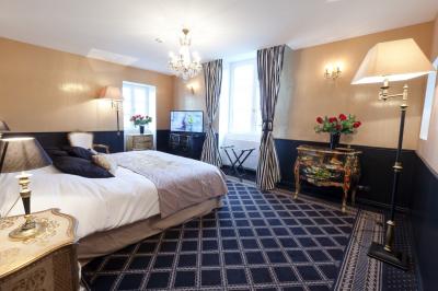 Deux jardinières sculptées sur un muret en pierre, entourées de végétation, avec une petite barrière en bois.