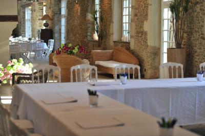 Deux jardinières sculptées sur un muret en pierre, entourées de végétation, avec une petite barrière en bois.