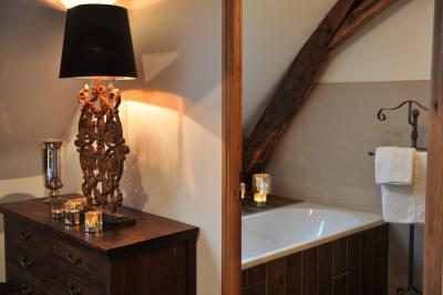 Deux jardinières sculptées sur un muret en pierre, entourées de végétation, avec une petite barrière en bois.