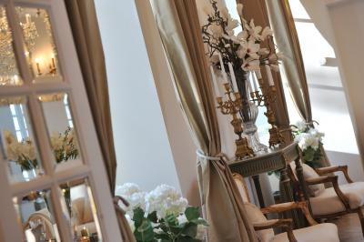 Deux jardinières sculptées sur un muret en pierre, entourées de végétation, avec une petite barrière en bois.