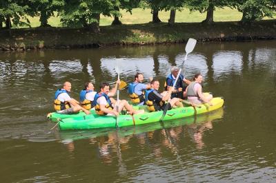 Deux jardinières sculptées sur un muret en pierre, entourées de végétation, avec une petite barrière en bois.