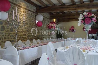 Des chèvres broutent de l'herbe dans un pré verdoyant, entourées d'arbres et d'une clôture en arrière-plan.