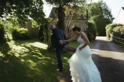 Des chèvres broutent de l'herbe dans un pré verdoyant, entourées d'arbres et d'une clôture en arrière-plan.