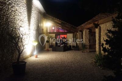 Salle de réception décorée avec des tables rondes dressées, des chaises blanches et des plantes entourant l'espace.
