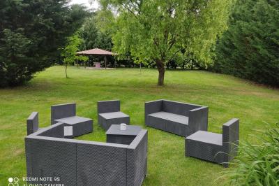 Salle de réception décorée avec des tables rondes dressées, des chaises blanches et des plantes entourant l'espace.