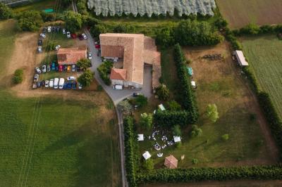 Salle de réception décorée avec des tables rondes dressées, des chaises blanches et des plantes entourant l'espace.