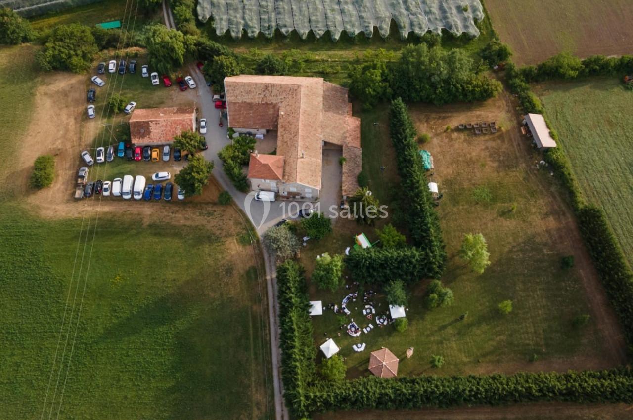 Vue aérienne d'une grande propriété rurale avec bâtiments en pierre, espaces verts et voitures stationnées.