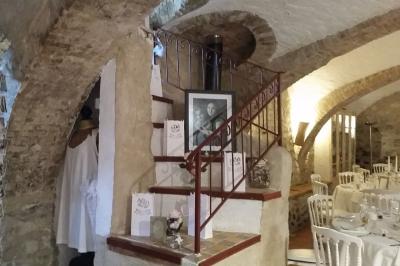 Salle de réception décorée avec des tables rondes dressées, des chaises blanches et des plantes entourant l'espace.