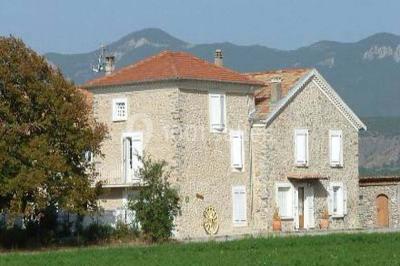 Salle de réception décorée avec des tables rondes dressées, des chaises blanches et des plantes entourant l'espace.