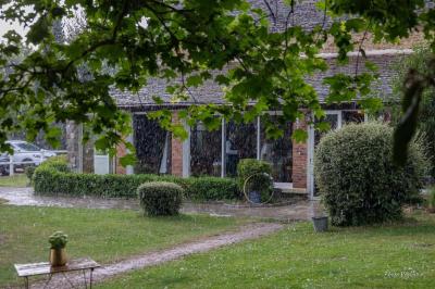 Grande table dressée avec nappes blanches, serviettes rouges, verres et couverts, décorée de bougies et fleurs au centre.