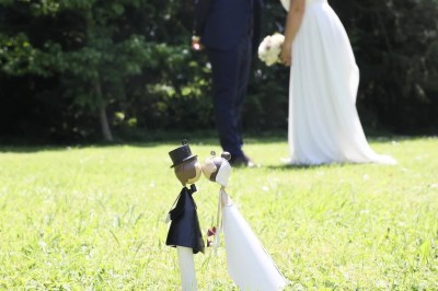 Grande table dressée avec nappes blanches, serviettes rouges, verres et couverts, décorée de bougies et fleurs au centre.