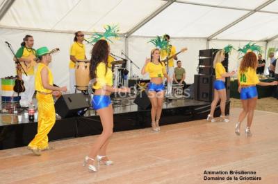 Un groupe de personnes posant debout dans une pièce avec des murs en pierre et une table en arrière-plan.