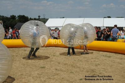 Un groupe de personnes posant debout dans une pièce avec des murs en pierre et une table en arrière-plan.