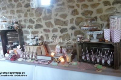 Un groupe de personnes posant debout dans une pièce avec des murs en pierre et une table en arrière-plan.