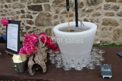 Un groupe de personnes posant debout dans une pièce avec des murs en pierre et une table en arrière-plan.