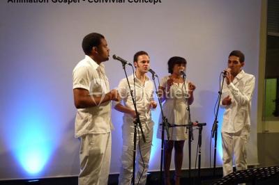 Un groupe de personnes posant debout dans une pièce avec des murs en pierre et une table en arrière-plan.