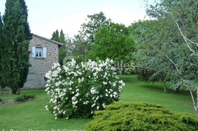 Un groupe de personnes posant debout dans une pièce avec des murs en pierre et une table en arrière-plan.
