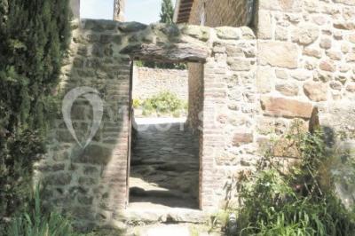 Un groupe de personnes posant debout dans une pièce avec des murs en pierre et une table en arrière-plan.